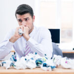 Businessman reflecting on financial decisions at a desk, surrounded by documents — symbolizing customer hesitation and emotional barriers in financial decision-making.