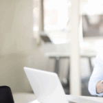 Professional designer reviewing an email layout on a laptop in a modern office
