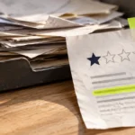 One-star customer review with a highlighted line beside a stack of feedback papers.